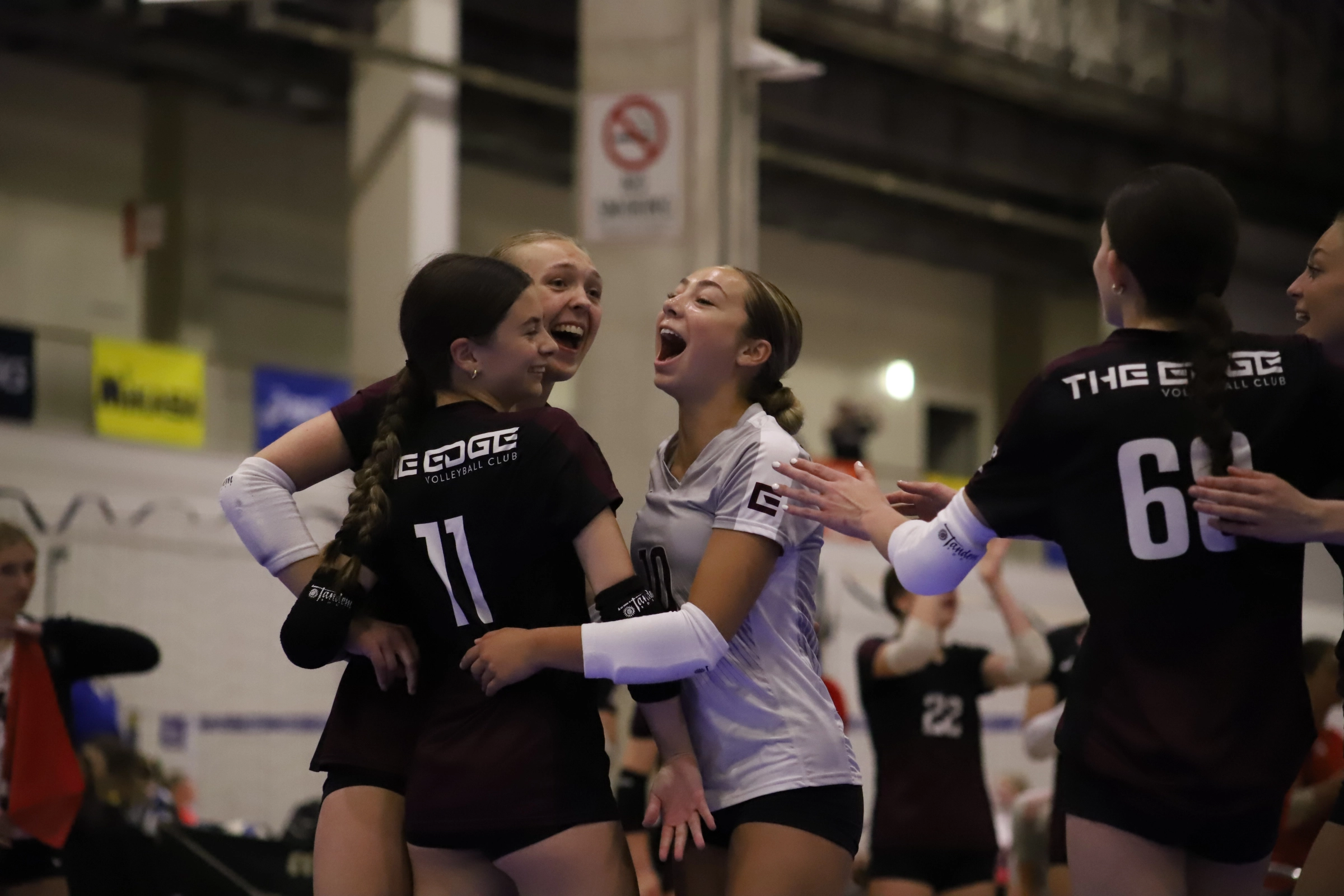 Group of Edge Volleyball athletes huddled around a coach.